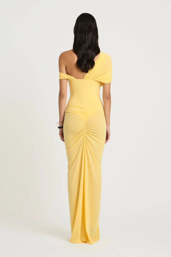Rumi Maxi Dress by Benni — an asymmetric stretch jersey dress with a gathered skirt and cascading split, offering sheer or solid styling options.