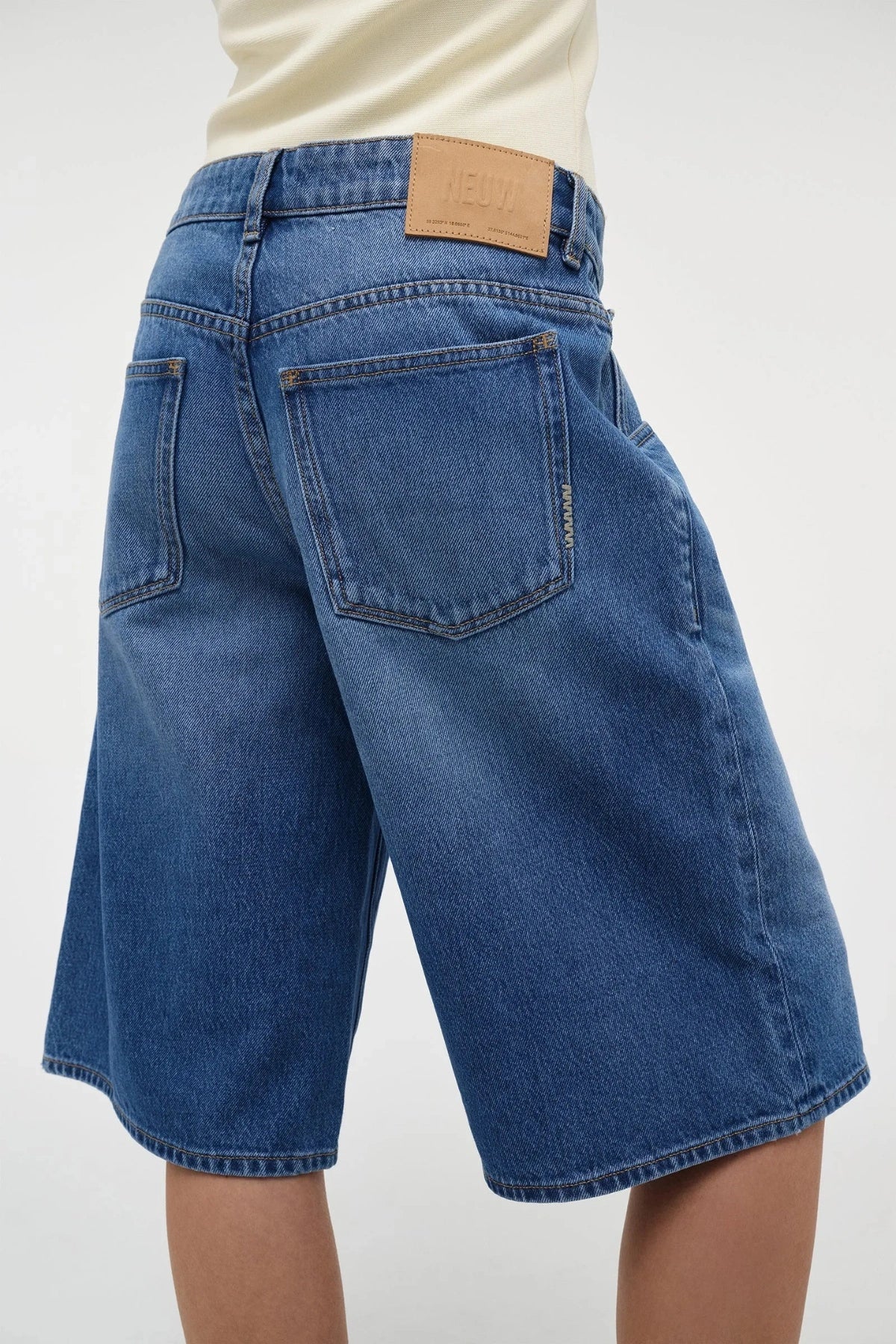 Sara Jort – Mesmerise by Neuw Denim, vintage-wash mid-rise jean shorts with relaxed fit. Perfect for summer days or laid-back weekends.