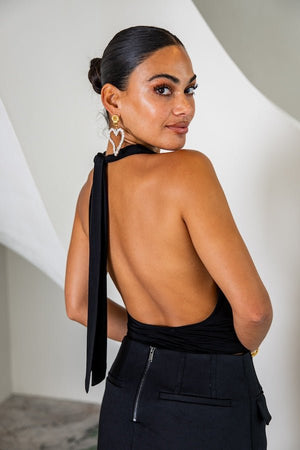 Saint Plunge Top Black by Sneaky Link – A seductive halter-neck tie top with a plunge neckline and low back. Made from a luxurious 90% cupro, 10% spandex blend, offering a silky feel and stretchy, form-fitting silhouette. Perfect for nights out or special occasions.