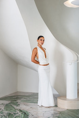 Saint Plunge Top Ivory by Sneaky Link – A sultry halter-neck tie top with a daring plunge neckline and low back. Crafted from a silky blend of 90% cupro and 10% spandex for a sleek, stretchy fit. Perfect for nights out or special occasions.