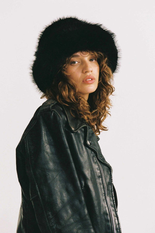 Snuggle Bucket Black by Lack of Color, a faux fur bucket hat with turnback brim and silky lining. Perfect for cozy winter styling.
