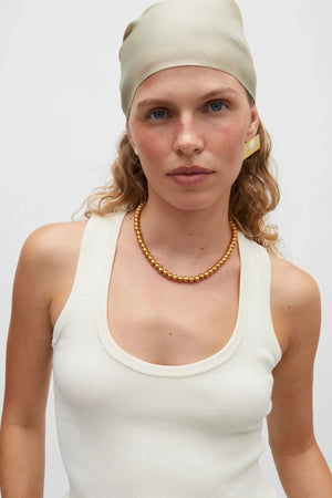 Sol Necklace Gold by Heaven Mayhem – polished gold bead necklace with signature S-clasp for layering.