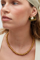 Sol Necklace Gold by Heaven Mayhem – polished gold bead necklace with signature S-clasp for layering.