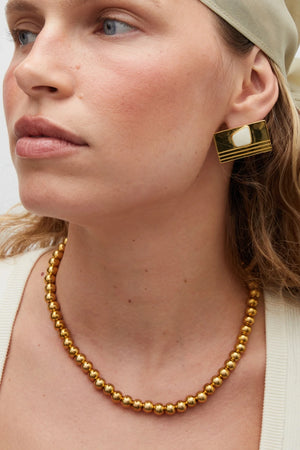 Sol Necklace Gold by Heaven Mayhem – polished gold bead necklace with signature S-clasp for layering.