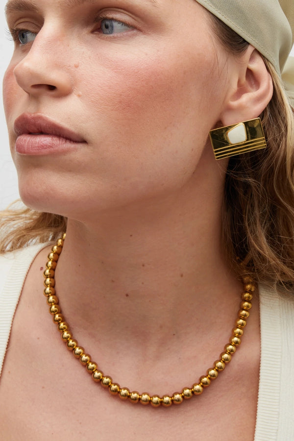Sol Necklace Gold by Heaven Mayhem – polished gold bead necklace with signature S-clasp for layering.