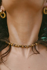 Sol Necklace Gold by Heaven Mayhem – polished gold beaded necklace with signature S clasp closure.