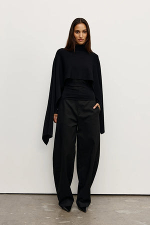 Sorella Poncho Black by Bayse – a draped knit poncho with mock neckline and relaxed fit. Perfect for layered styling.