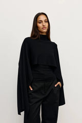 Sorella Poncho Black by Bayse – a draped knit poncho with mock neckline and relaxed fit. Perfect for layered styling.