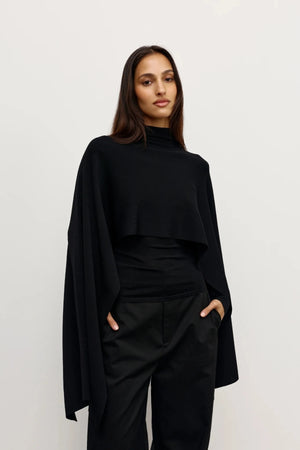 Sorella Poncho Black by Bayse – a draped knit poncho with mock neckline and relaxed fit. Perfect for layered styling.