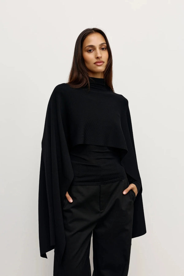 Sorella Poncho Black by Bayse – a draped knit poncho with mock neckline and relaxed fit. Perfect for layered styling.