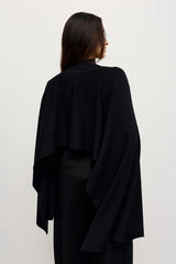 Sorella Poncho Black by Bayse – a draped knit poncho with mock neckline and relaxed fit. Perfect for layered styling.