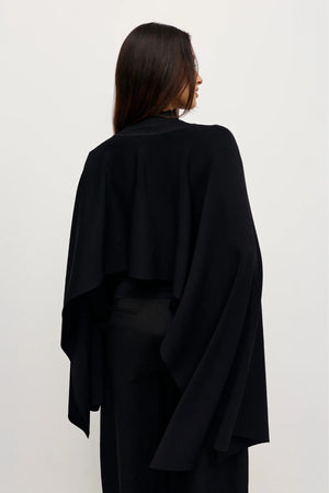 Sorella Poncho Black by Bayse – a draped knit poncho with mock neckline and relaxed fit. Perfect for layered styling.