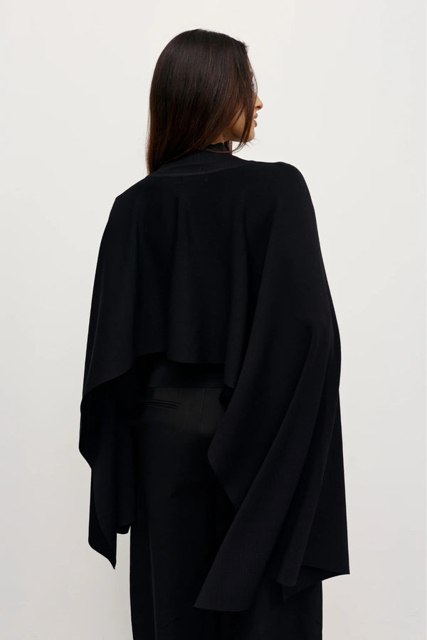 Sorella Poncho Black by Bayse – a draped knit poncho with mock neckline and relaxed fit. Perfect for layered styling.