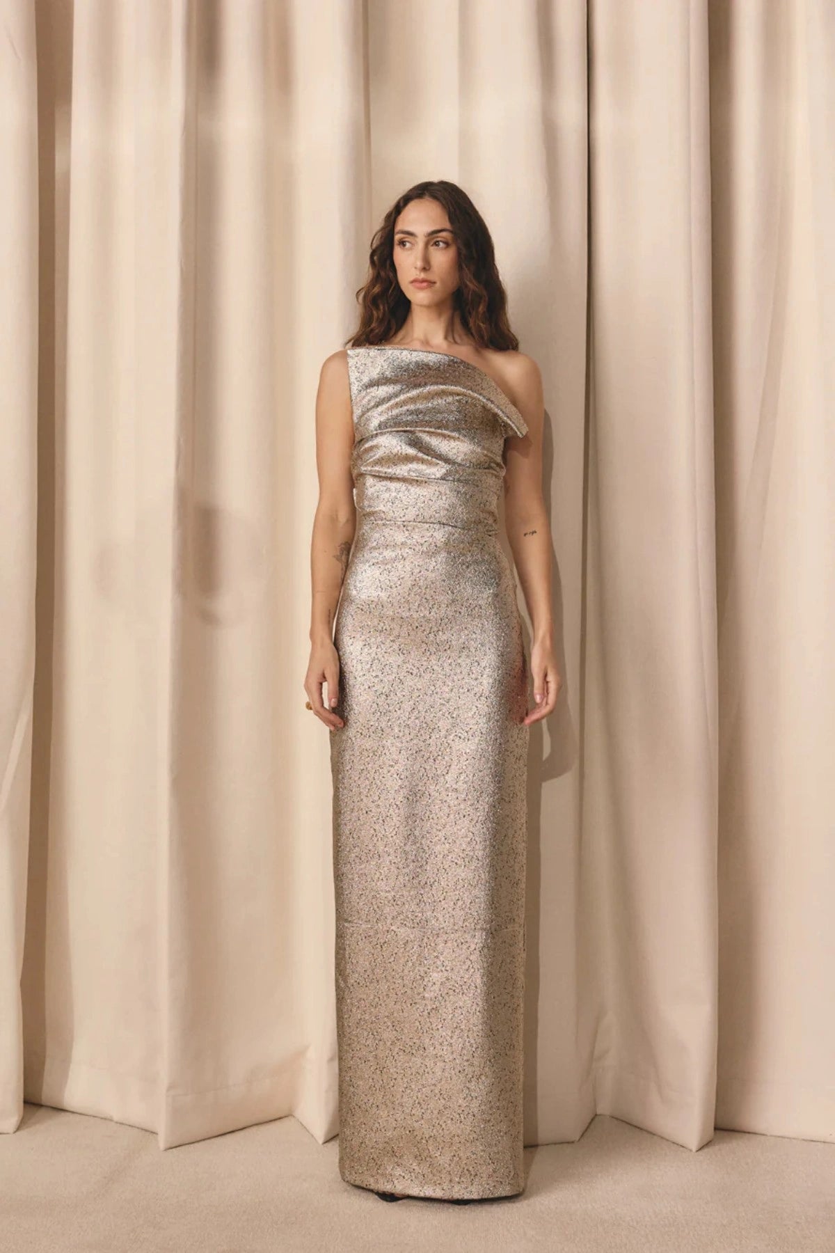 Tacoma Dress by Tojhà, a metallic champagne strapless gown with fold-over neckline, side tucks, and back split for sculptural elegance.
