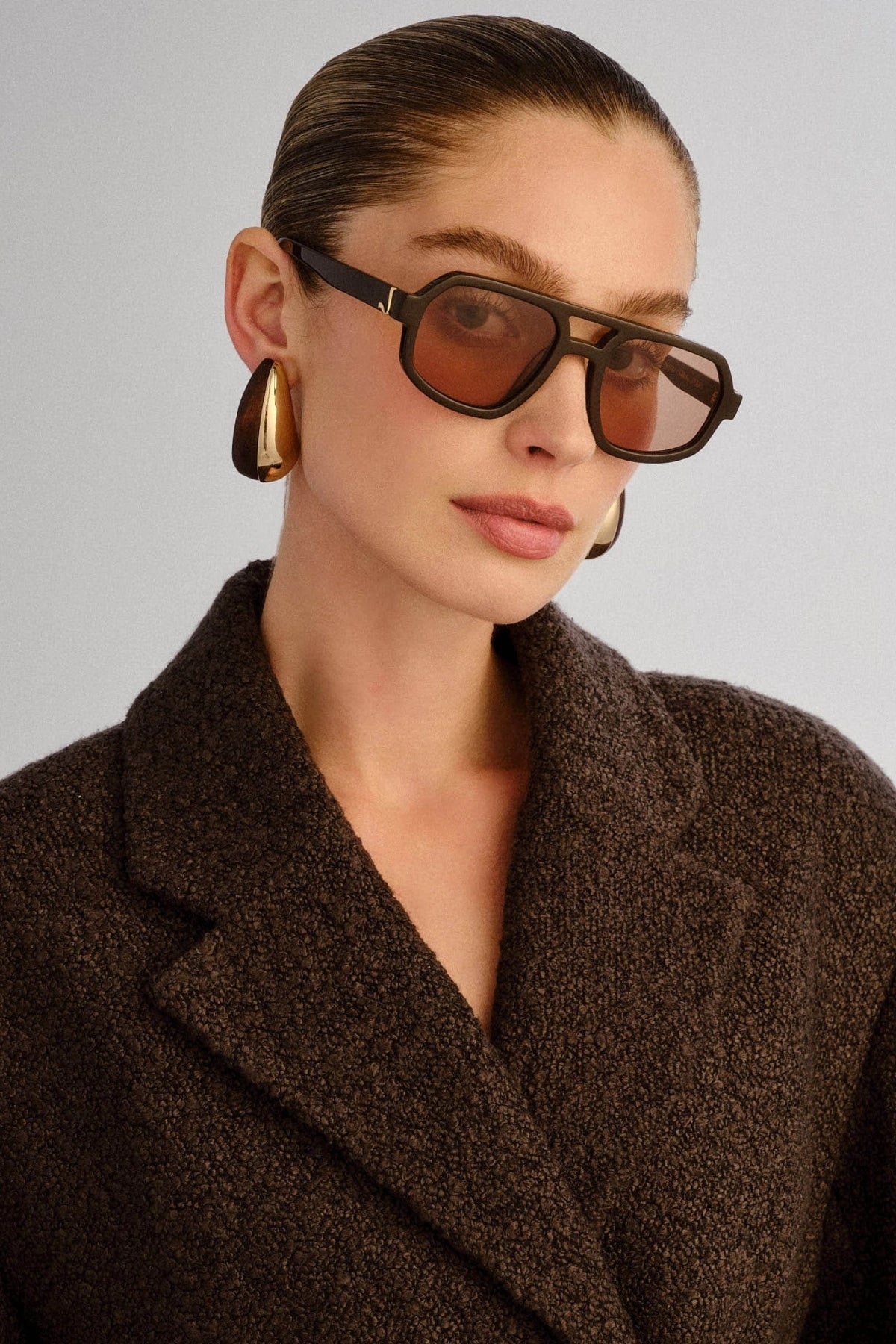 The Banks Sunglasses Dark Chocolate by Luv Lou – oversized aviator with gold hardware and brown tint lenses in premium dark chocolate finish.
