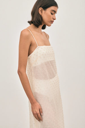 The Camilla Dress Beaded Ivory by Solaqua – sheer beaded maxi dress with geometric embellishments and elegant drape.
