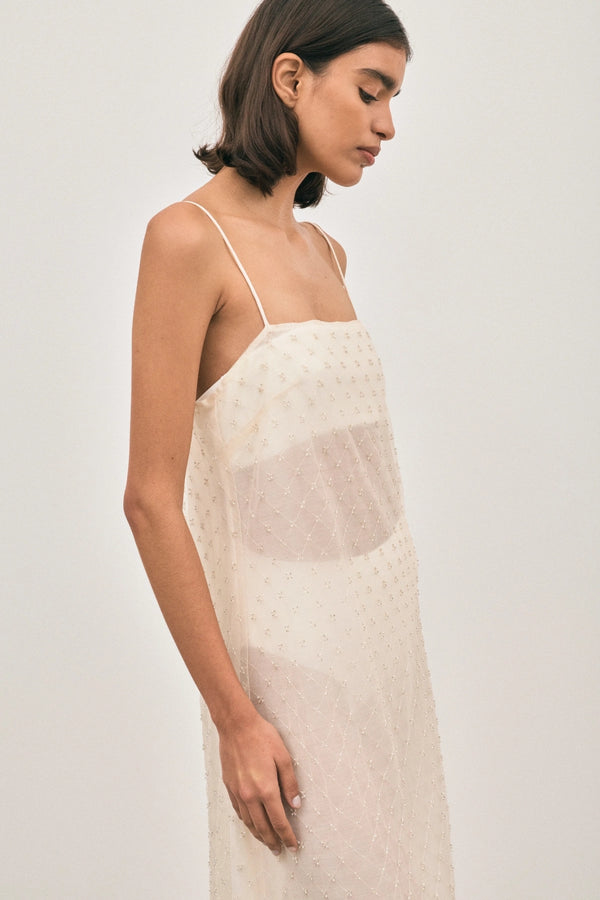 The Camilla Dress Beaded Ivory by Solaqua – sheer beaded maxi dress with geometric embellishments and elegant drape.