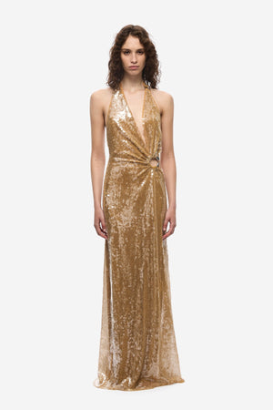 The Devon Sequin Dress by Misha, a mustard gold halter gown with cut-outs and ring detail. Perfect for parties, red carpets, or weddings.