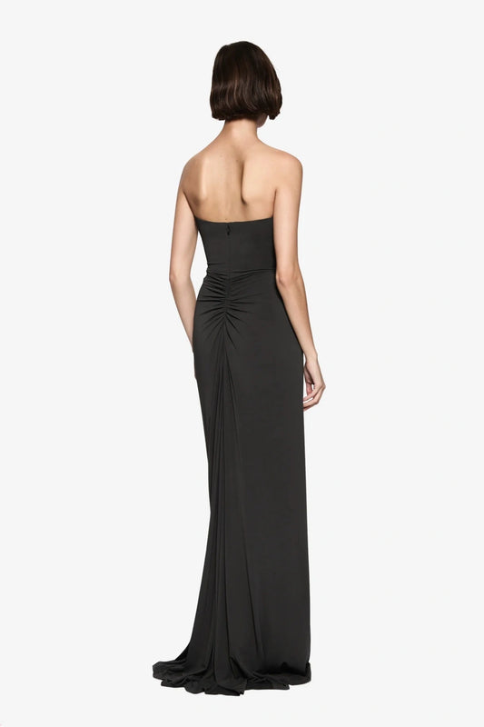 The Florence Jersey Dress by MISHA, a strapless black maxi with plunge neckline and ruching. Perfect for black-tie or evening events.
