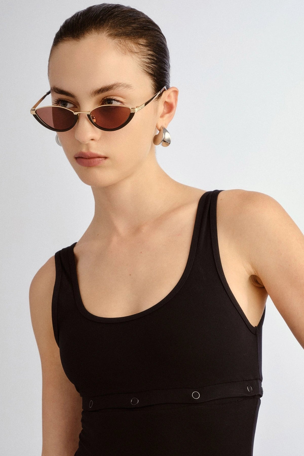 The Lia sunglasses by Luv Lou, black cat-eye frame with metal accents and debossed Organic L pattern, featuring smoke mono lenses.