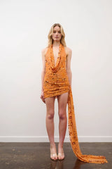 Tiffany Dress in Orange Floral Beaded by DŽO, an embellished mesh mini with cowl neckline, ruched detailing, and asymmetrical train hem.