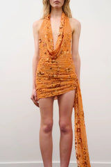 Tiffany Dress in Orange Floral Beaded by DŽO, an embellished mesh mini with cowl neckline, ruched detailing, and asymmetrical train hem.