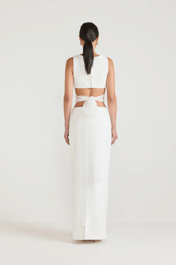 Bellina Dress Black by Tojhà, a sculptural crepe maxi with waist cut-out and mesh tie detail. Perfect for striking modern evening looks.