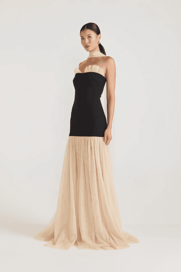 Strapless Maxi Gown Black by Tojhà, a bold crepe silhouette with sheer mesh skirt and ruffle neckline. Perfect for standout formal events.