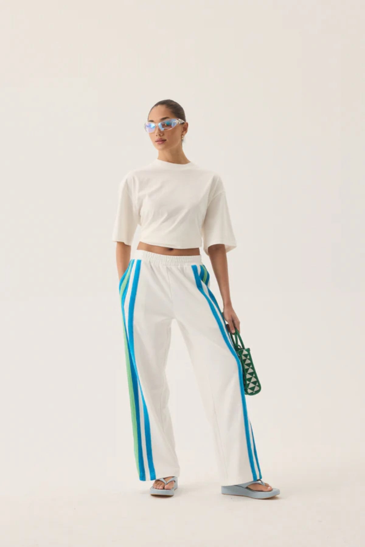 Vacation Sporty Pant by Araminta James — a white wide-leg sports-sheen pant with velour trims and elastic waist, perfect for relaxed styling.