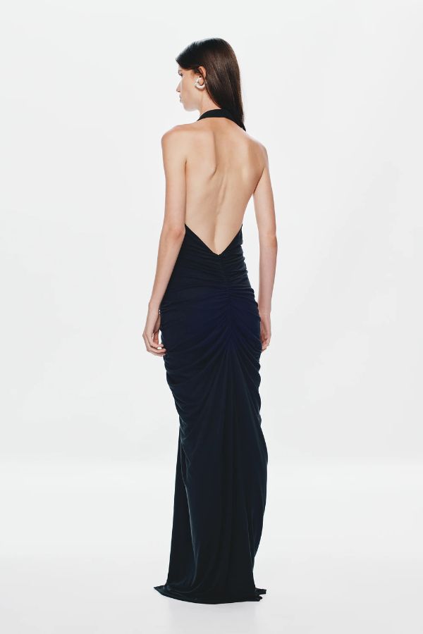 Venus Gathered Cupro Maxi Dress by Misha, a black plunging halter gown with ruched draping and mermaid hem. Perfect for formal events.
