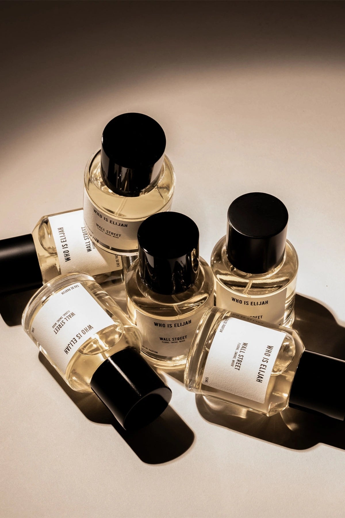 Wall Street by Who Is Elijah, a floral, smoky, and woody fragrance with rose, raspberry, oud wood, incense, saffron, amberwood, benzoin, and leather.