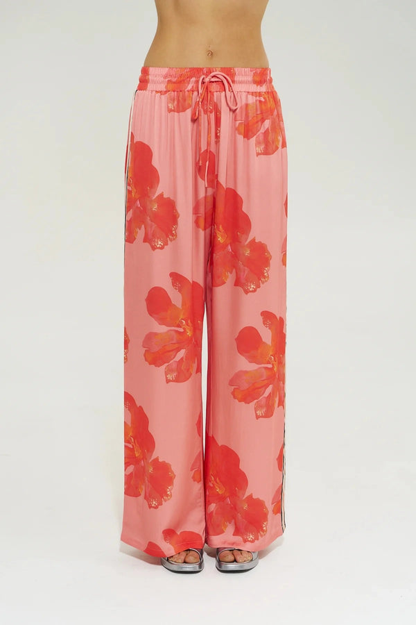 Wide Leg Pant Peach Petals by Summi Summi, features oversized floral prints on a flowy peach base. Perfect for resort lounging or beach days.