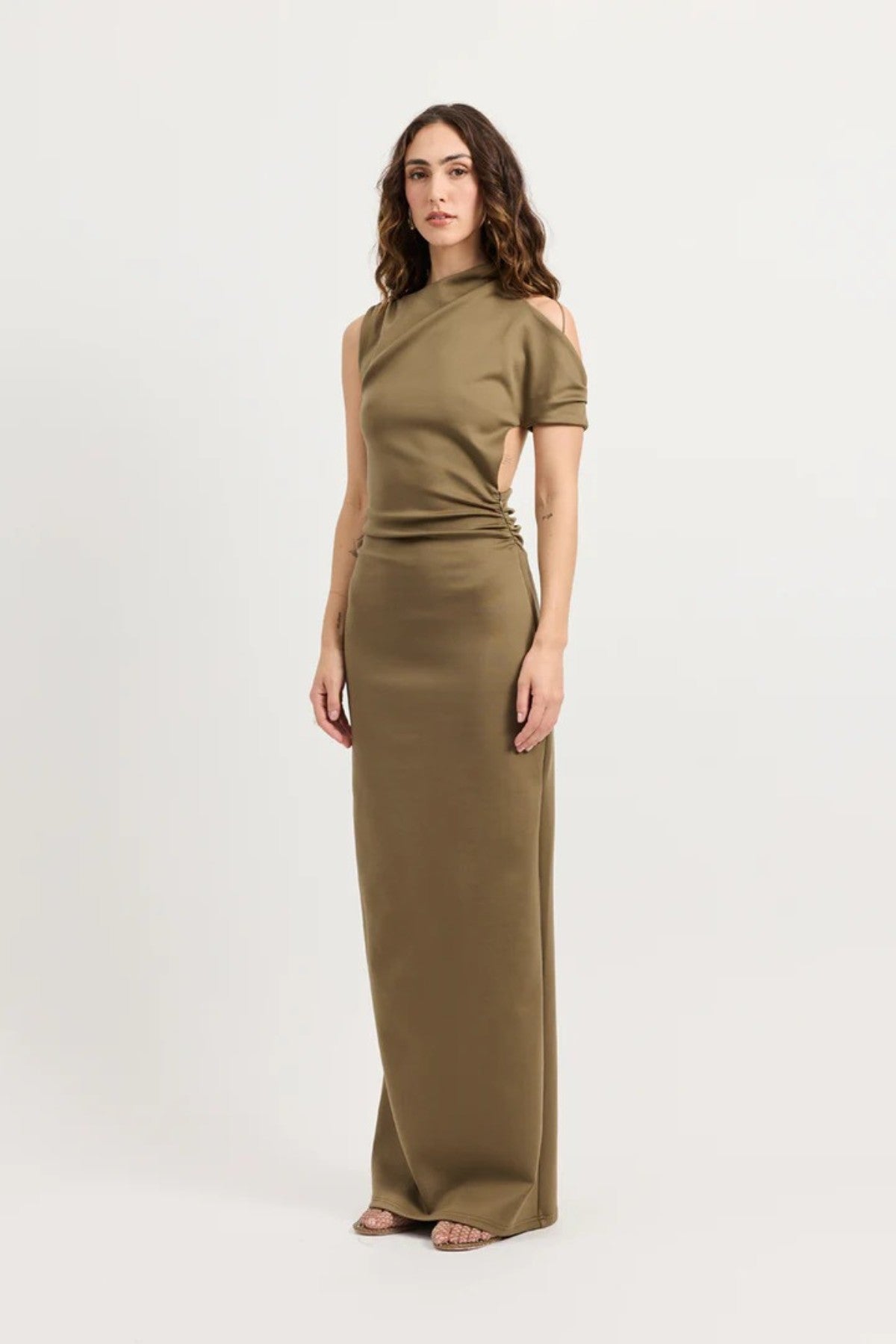 Xyla Dress by Tojhà – a clay jersey maxi with an asymmetric neckline, wrapped arm detail, and soft tucks, perfect for modern evening styling.