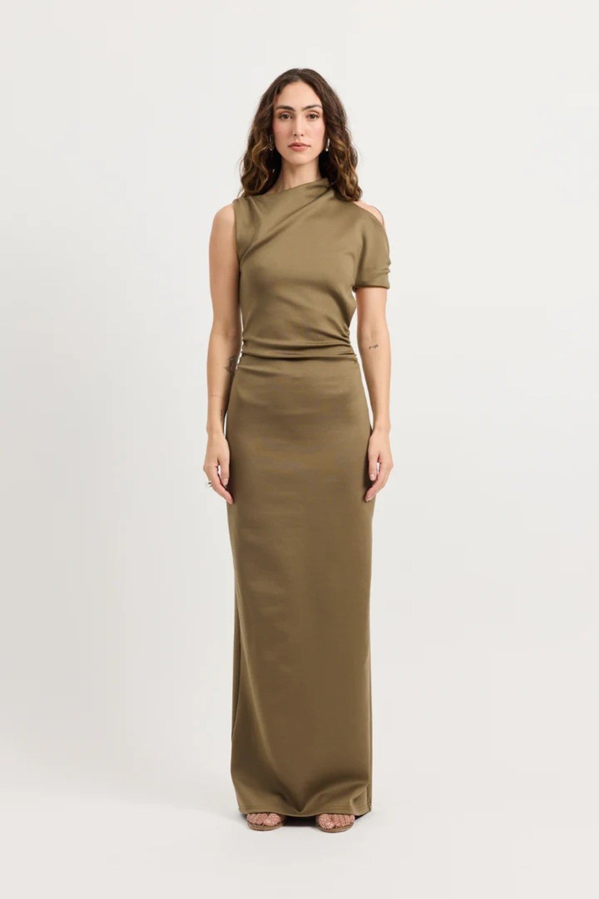Xyla Dress by Tojhà – a clay jersey maxi with an asymmetric neckline, wrapped arm detail, and soft tucks, perfect for modern evening styling.