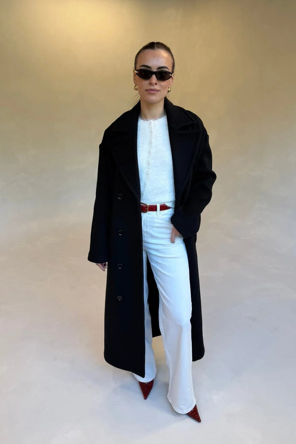 Black double-breasted coat with wide lapels and front buttons, designed for a tailored fit.