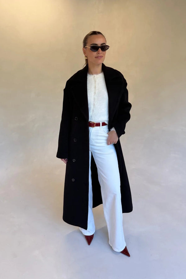 Black double-breasted coat with wide lapels and front buttons, designed for a tailored fit.