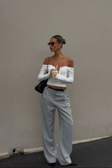White off-shoulder top with ruffled neckline and short sleeves, styled on a mannequin.