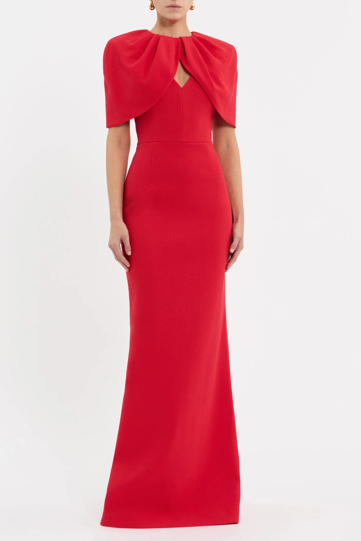 Rebecca Vallance Cameron Gown in red bonded crepe with draped cape overlay, V neckline and column maxi skirt, elegant evening style.
