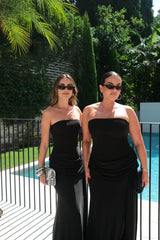 Black strapless maxi dress with a thigh-high split and flowing skirt, styled on a mannequin.