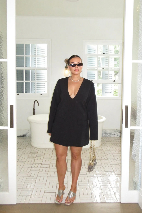 Black long sleeve mini dress with a tailored fit and subtle suiting texture, styled with a classic collar and button details.