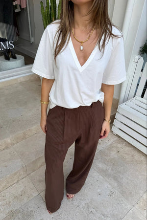 Kinsley Pinstripe Tailored Pant in chocolate brown with thin vertical white stripes and a slim, tailored fit.