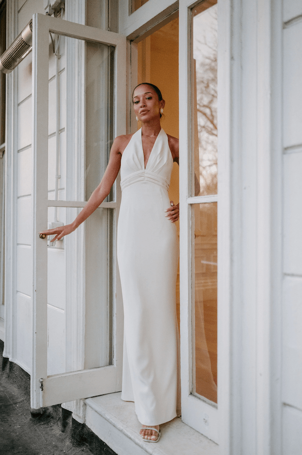 The Ultimate Muse Tie Neck Maxi Dress Butter Cream by Odd Muse – A viral bridal favorite featuring a flattering V-neck, draped shoulders, and elegant low back, perfect for all-night celebrations.