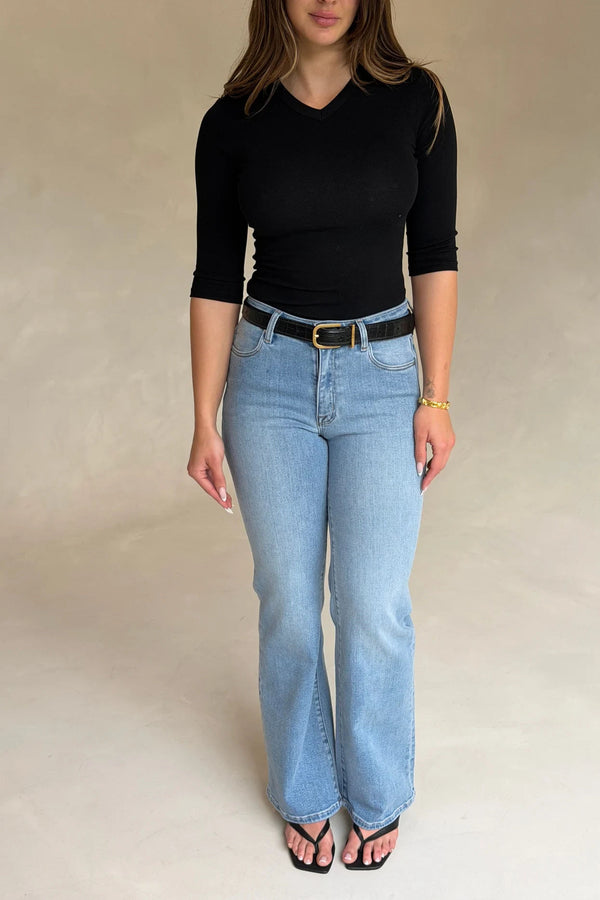 Woman wearing a Renee Leather Belt Black Croc with a fitted black top, light-wash jeans, gold bracelet, and black strappy sandals.