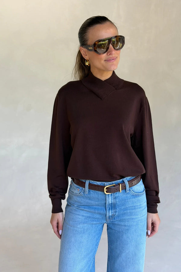 Woman wearing a Renee Leather Belt Chocolate with croc-embossed brown leather and gold buckle, styled with light jeans and a dark sweater.