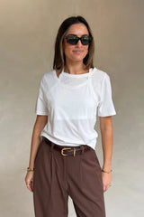 Woman wearing a Renee Leather Belt Chocolate with brown pinstriped trousers, white layered tee, gold jewelry, and black sunglasses.