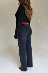 A woman in black jeans and top wears the Renee Leather Belt Red Croc with matching red crocodile-embossed pointed heels.