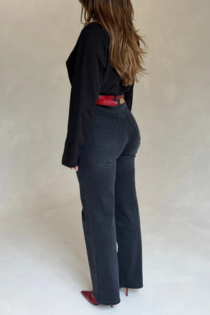 A woman in black jeans and top wears the Renee Leather Belt Red Croc with matching red crocodile-embossed pointed heels.