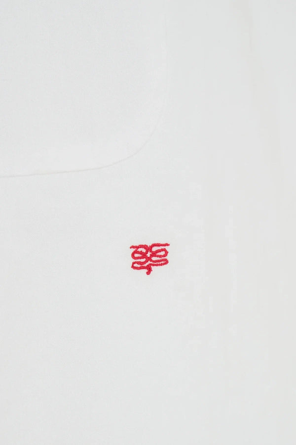 White oversized shirt with long sleeves and a relaxed fit, featuring a classic collar and button-down front.