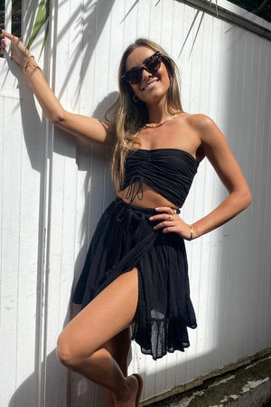 Ruched Tube Top Black by D’Artemide, Cotton bandeau with ruched back and front tie detail for easy summer layering or elevated resort styling.