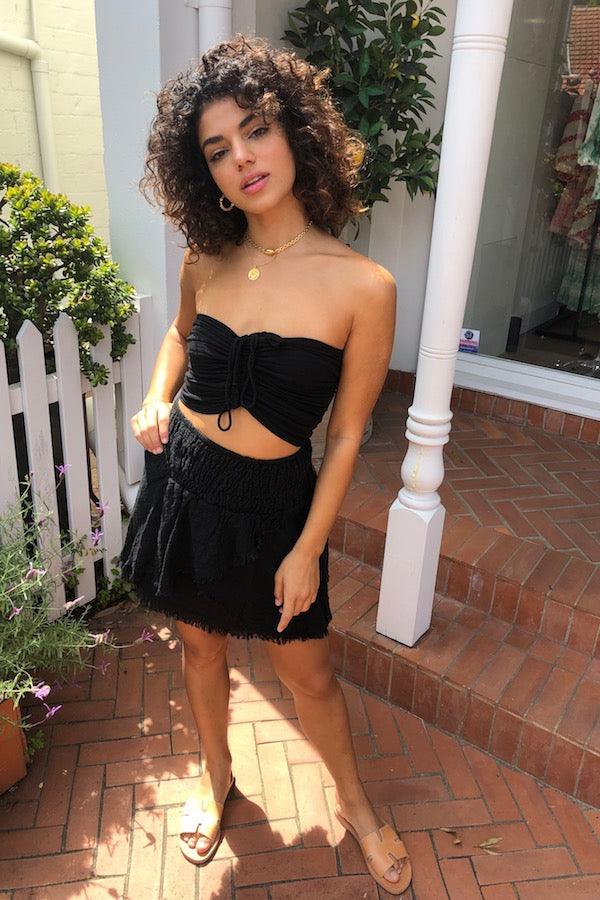 Ruched Tube Top Black by D’Artemide, Cotton bandeau with ruched back and front tie detail for easy summer layering or elevated resort styling.